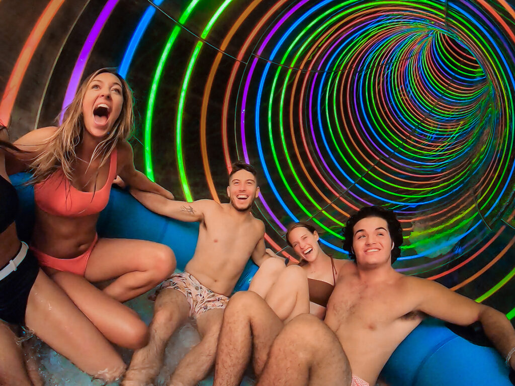 a group of friends enjoying the slide down profile plunge at island h20