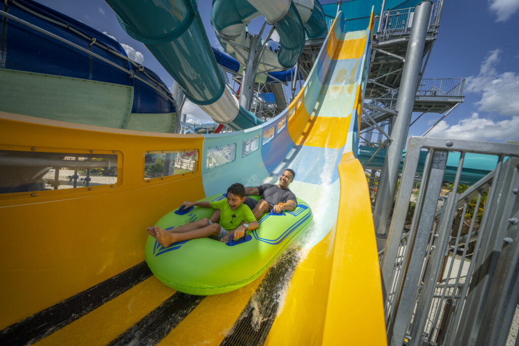 a dad and his son enjoying the slide down follow me falls at island h20