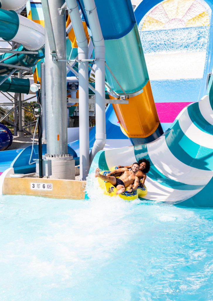 people going down water slide in tube